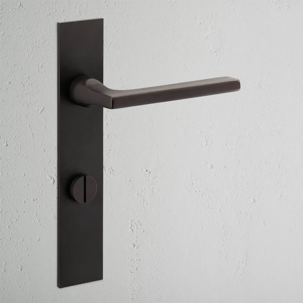 Manilla para puertas Clayton con placa larga (con muelle) y sistema giratorio - Bronce
