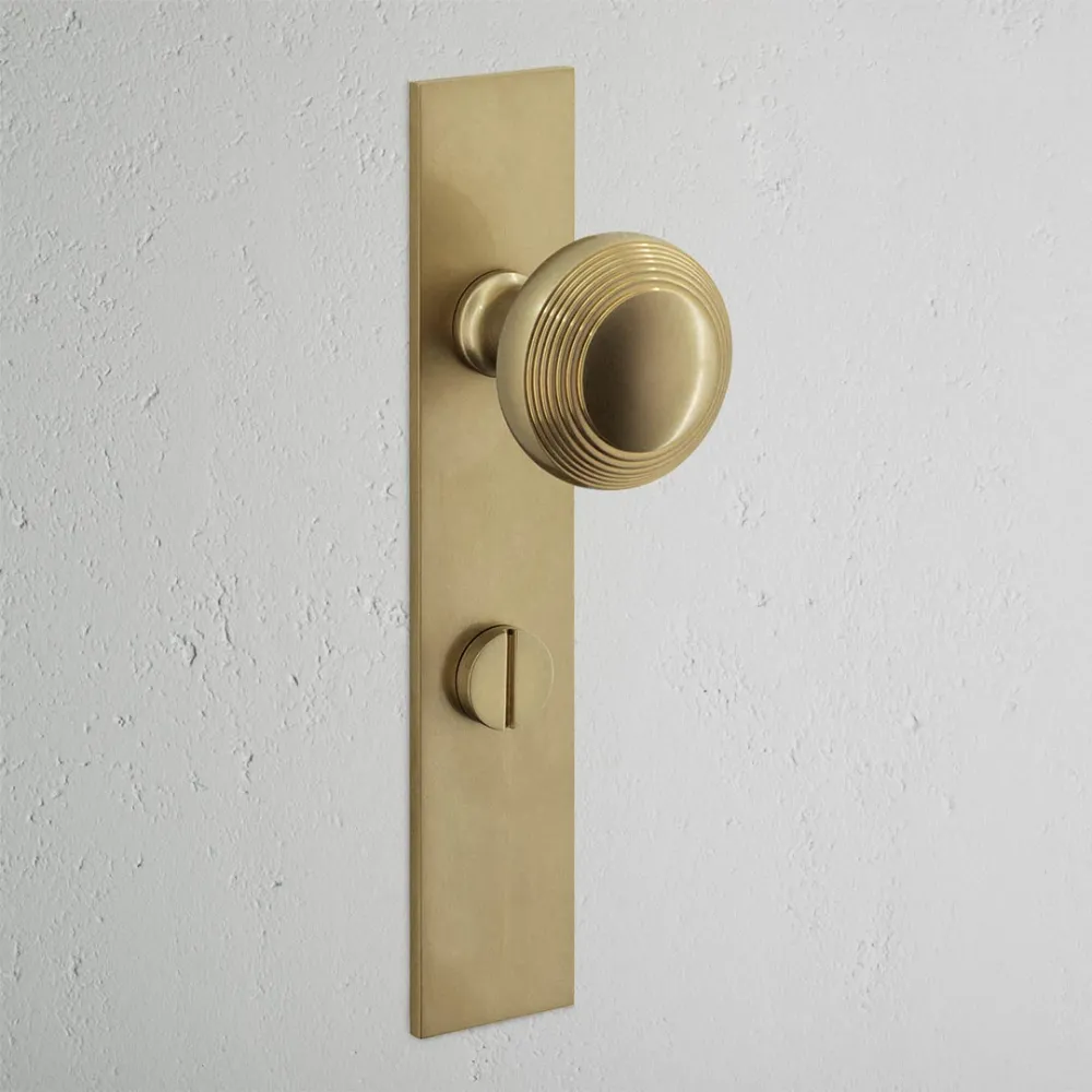 Pomo para puertas Poplar con placa larga (con muelle) y sistema giratorio - Latón antiguo